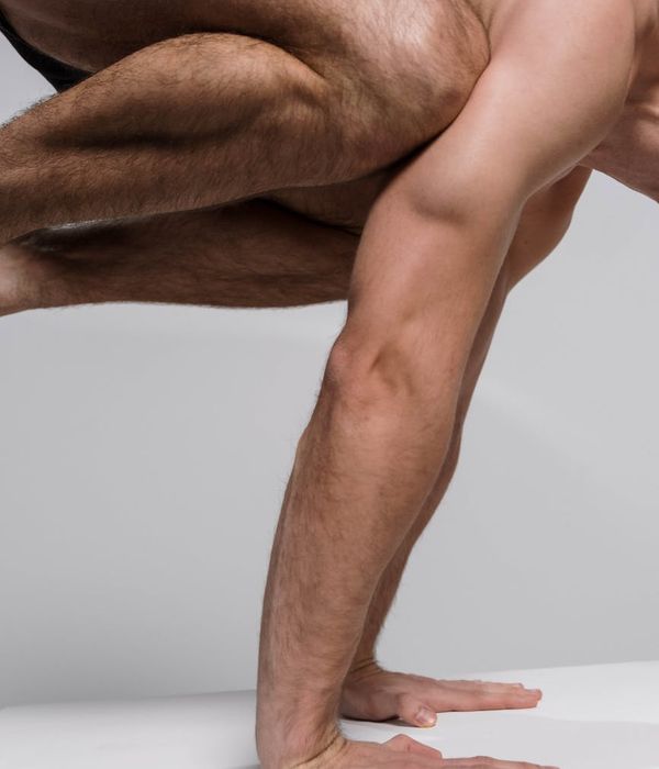 A fit man standing in a balanced, powerful pose, showcasing physical control and stability.